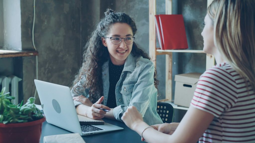 Deux femmes échangent autour d’un bureau