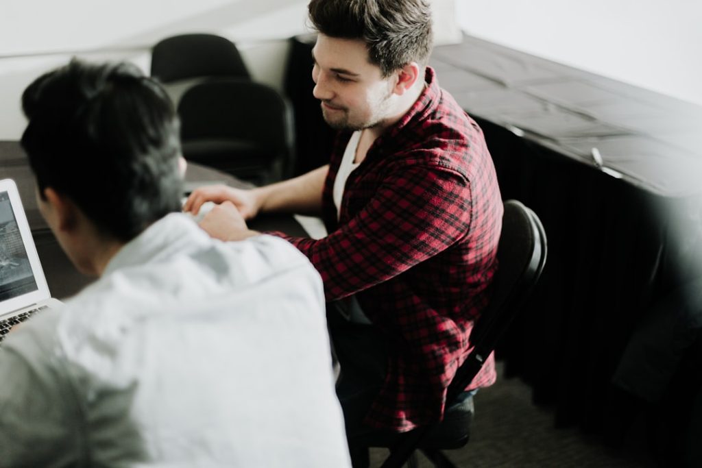 Deux professionnels échangent à une table de travail
